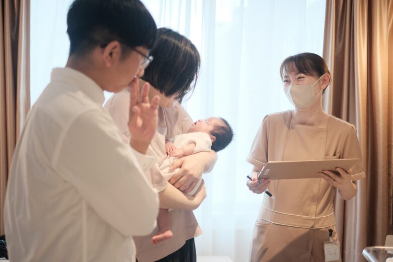 産後ケアホテルCocokaraで助産師が赤ちゃんを抱いた母親に優しく声をかけている様子