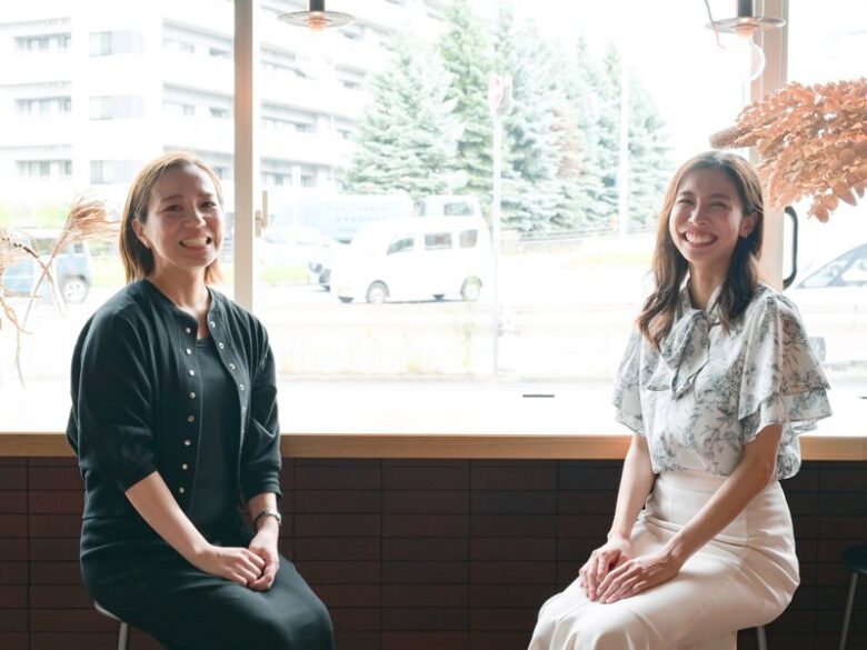 窓辺で座りながら微笑む代表と副代表の様子