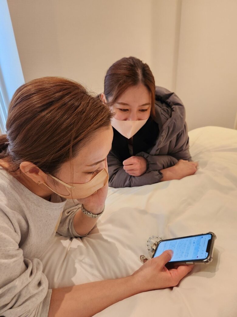 産後ケアホテルCocokaraの高橋と美里が、HBCのWEBメディア「Sitakke」に掲載された連載記事をスマートフォンで確認している様子。